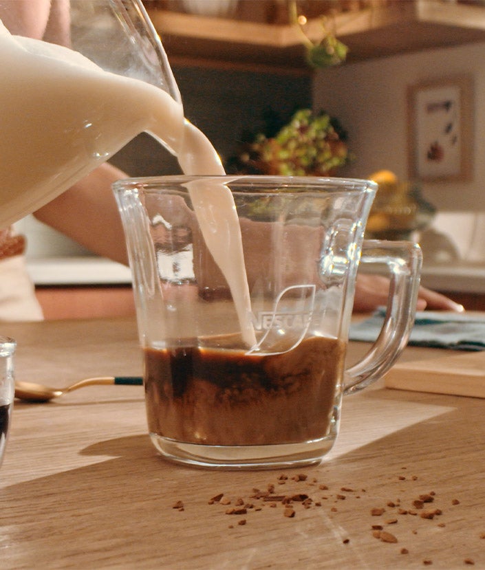 Verter la leche en la taza de café