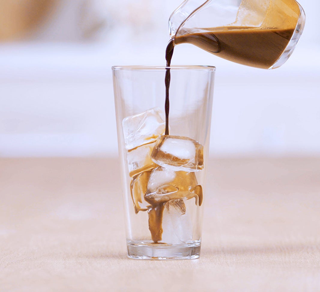 Pouring NESCAFÉ® Espresso over a glass of ice