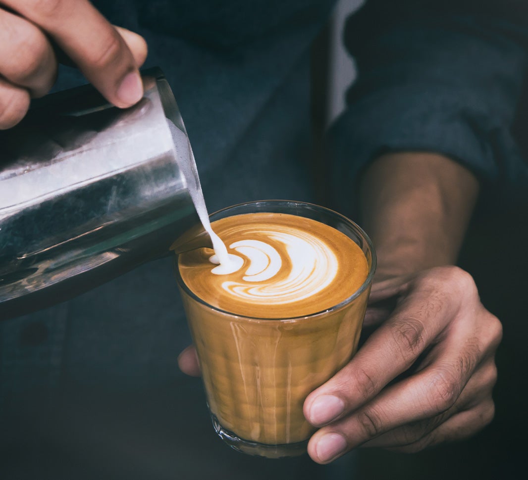 Pouring frothed milk to make a flat white