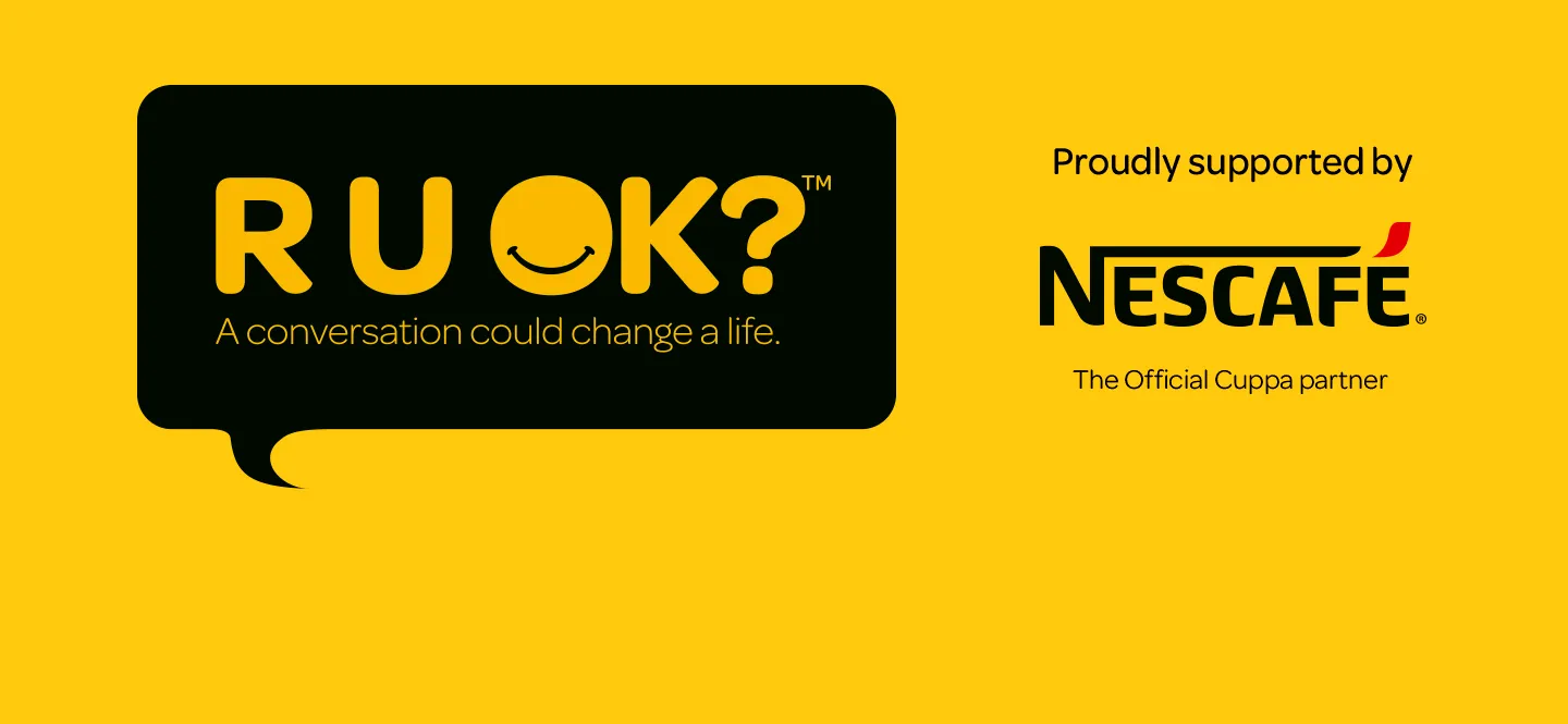 Yellow banner with black speech bubble reading “R U OK? A conversation could change a life.” and Nescafé logo with text “Proudly supported by Nescafé, The Official Cuppa partner.