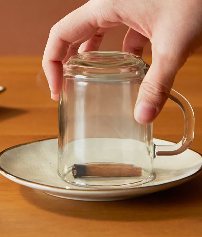 Smilkstanti cinamono lazdelė uždengta puodeliu