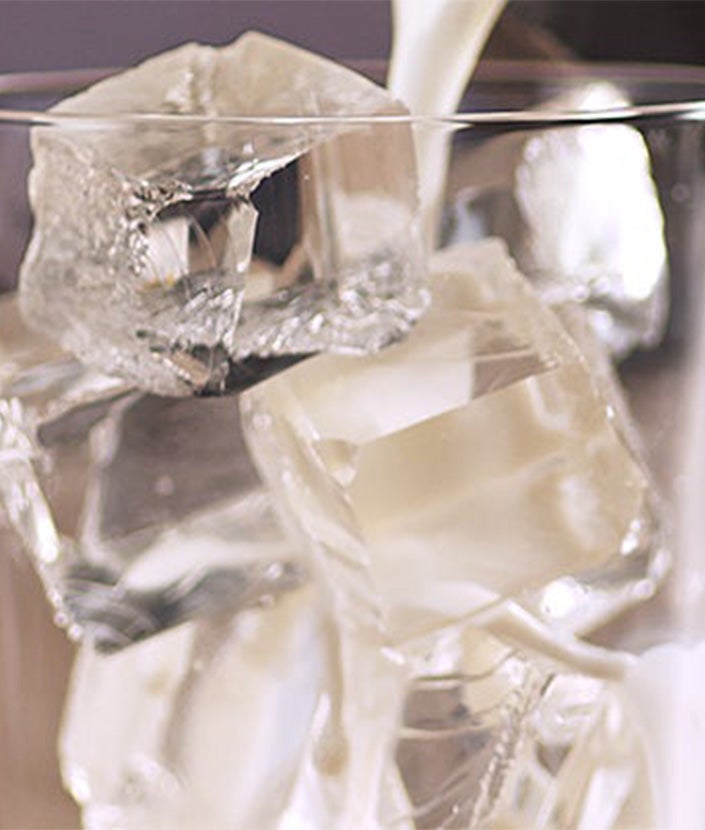 Saputoto pienu pārlej glāzē esošajiem ledus kubiciņiem.