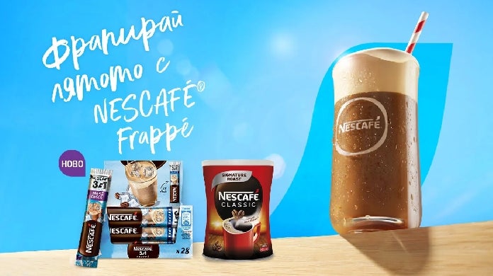 Стъклена чаша с напитка NESCAFÉ Frappé на масата