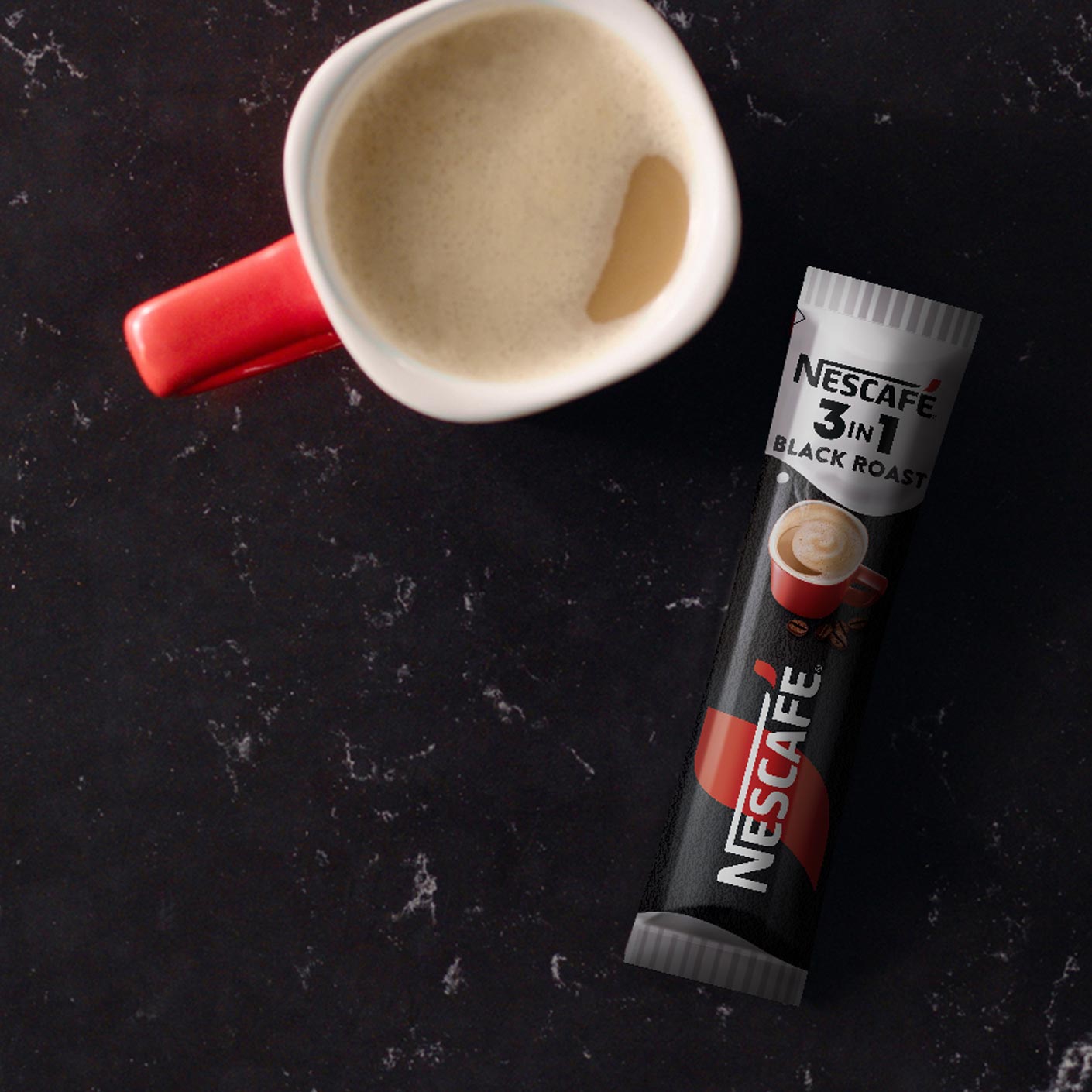 NESCAFÉ 3in1 Black Roast пакетче върху черна мраморна повърхност