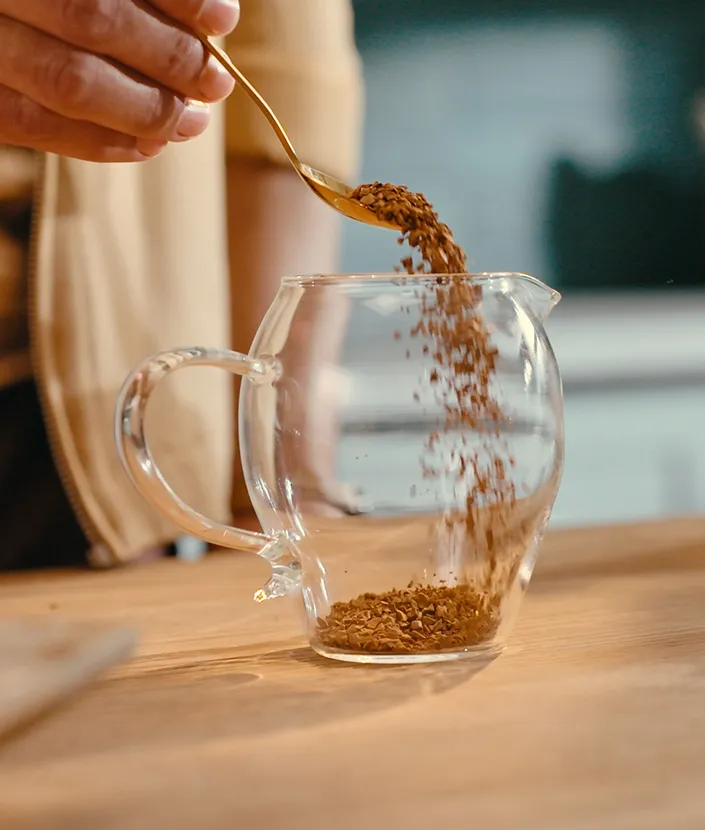 Adicionando pó de café a uma xícara