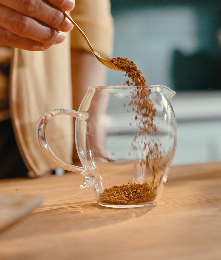 Adding coffee powder in a cup