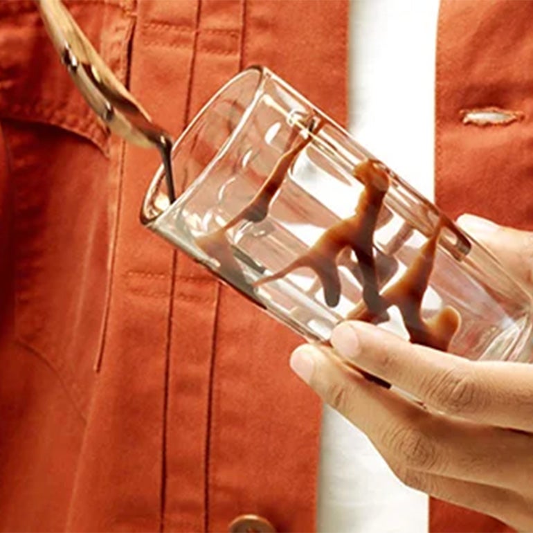 Personne décorant un verre de sauce chocolat