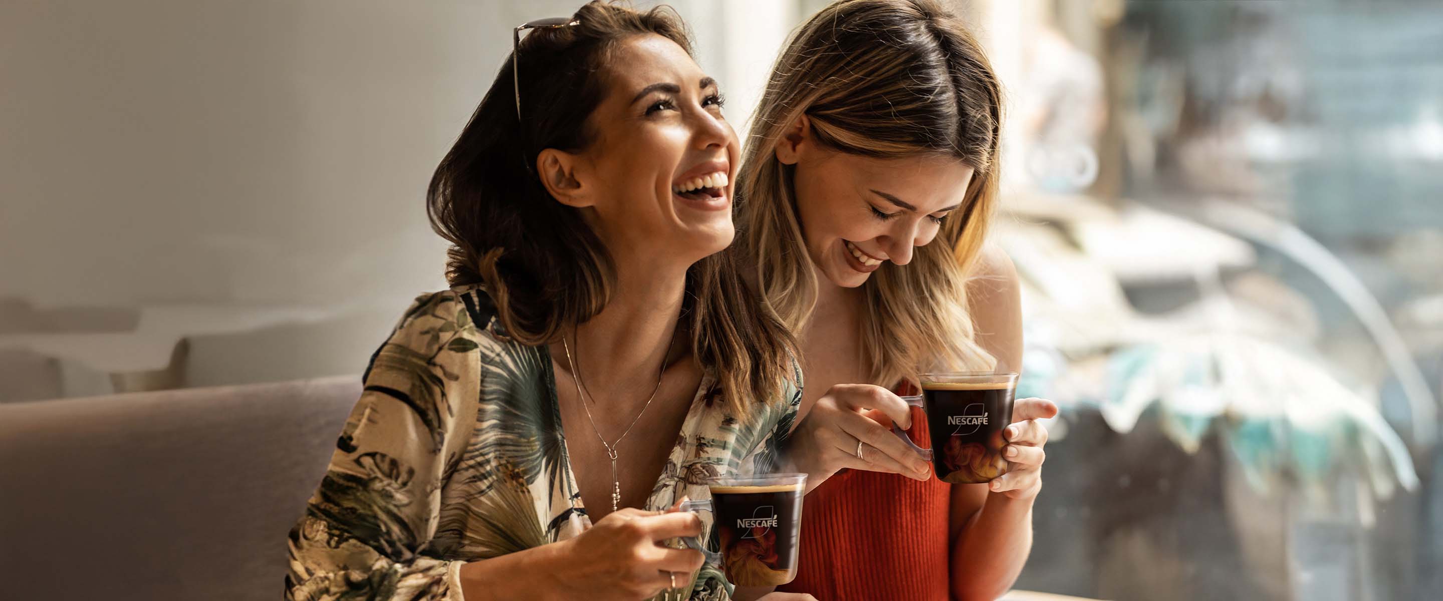 Des filles qui rient et boivent du café