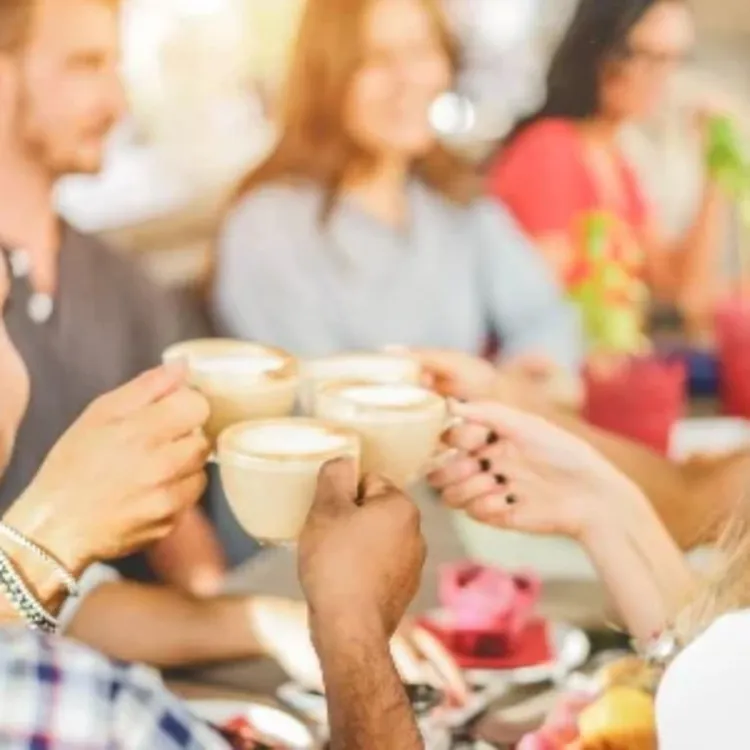Four people celebrating with a coffee each