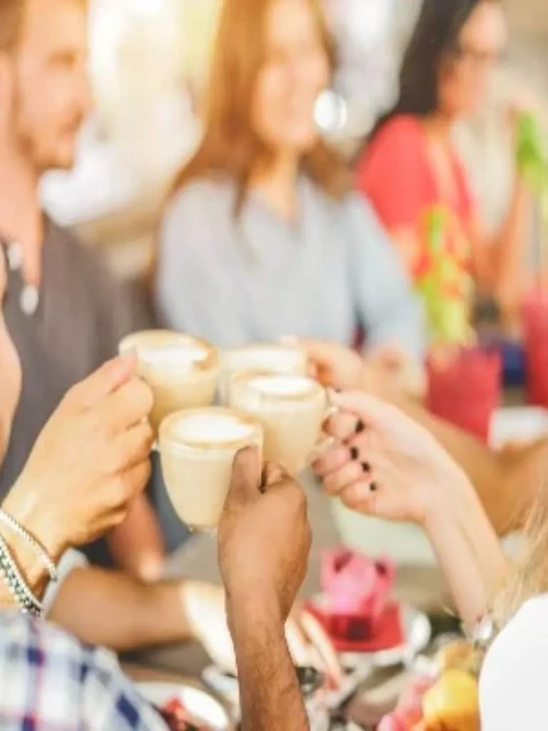 Four people celebrating with a coffee each