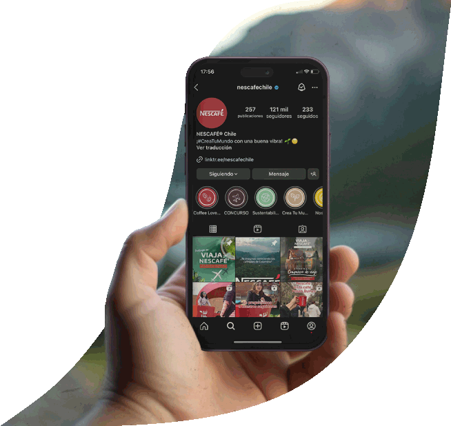 Una mano sosteniendo un teléfono que muestra la cuenta de Instagram de Nescafé