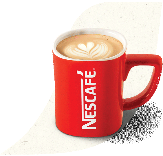 Una taza de caramel latte hecho con Nescafé con un corazón diseñado en su espuma