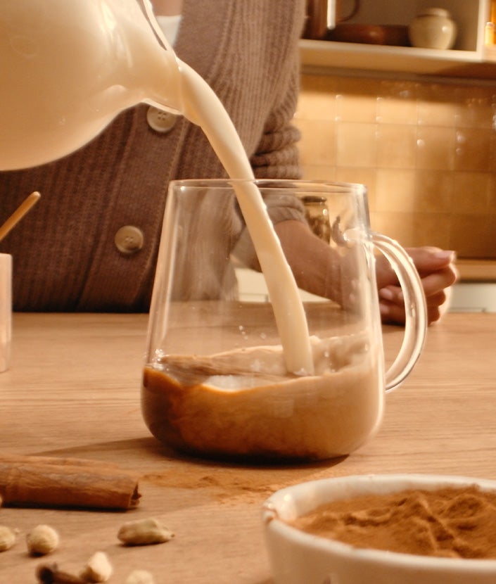 Mujer añadiendo leche al café