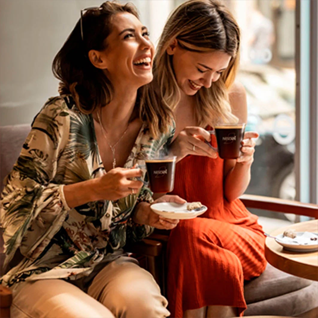 Mujer en su computador tomando café 