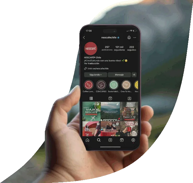 Una mano sosteniendo un teléfono que muestra la cuenta de Instagram de Nescafé