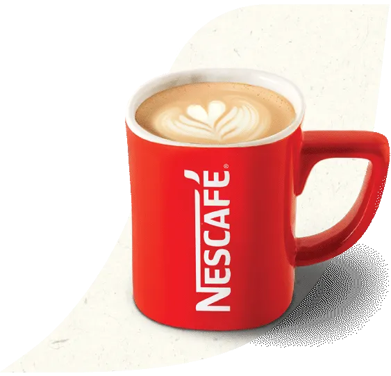 Una taza de caramel latte hecho con Nescafé con un corazón diseñado en su espuma