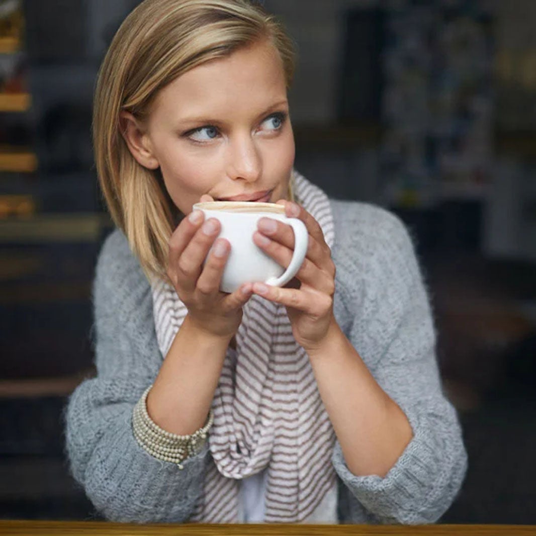 Mujer tomando su taza de café hecha en casa