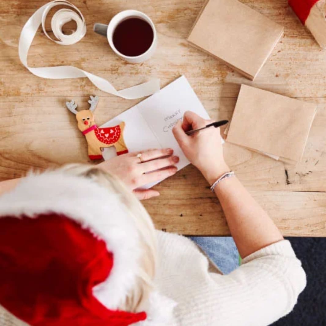 manos sosteniendo cafe rodeado de regalos