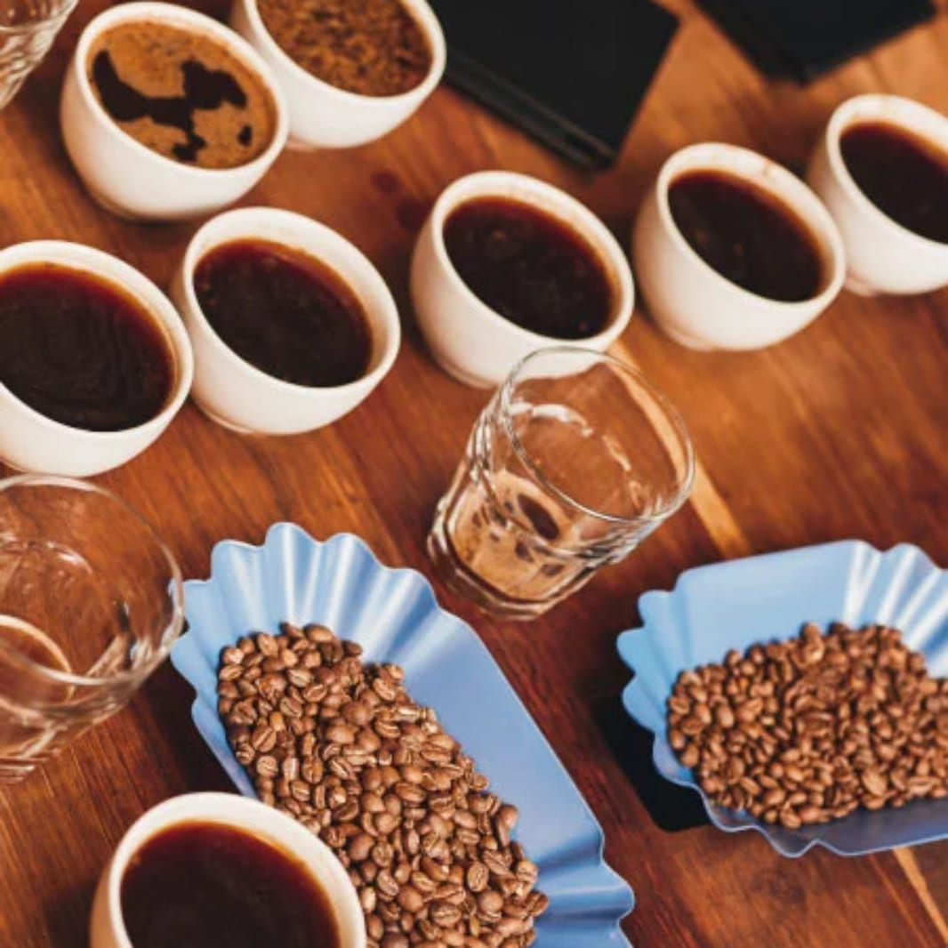 mesa con infusión y granos de cafe en recipientes