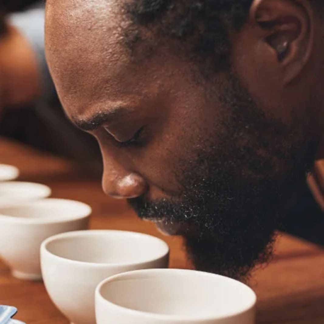 hombre oliendo taza blanca con cafe