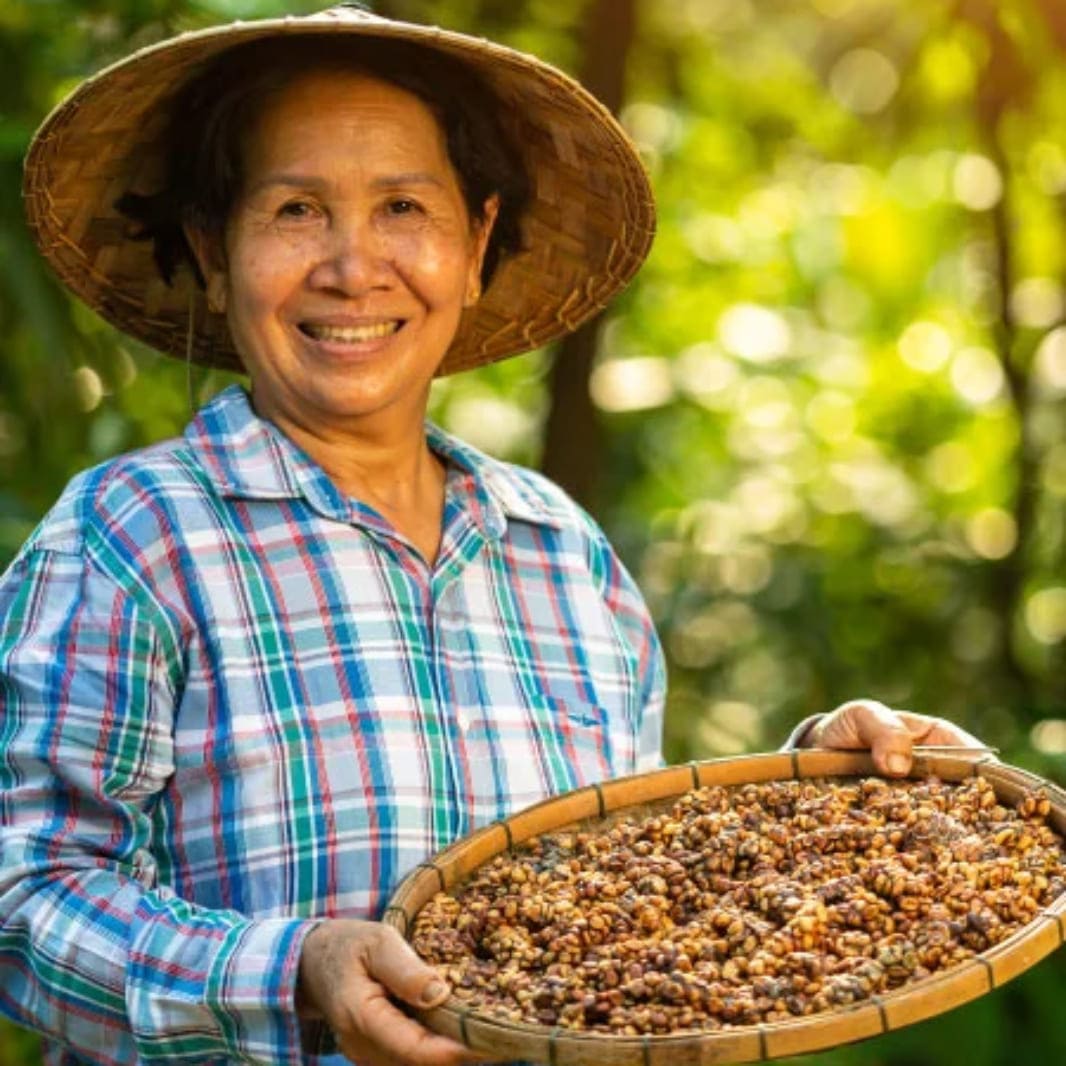 Mujer sonriendo entre cafetales