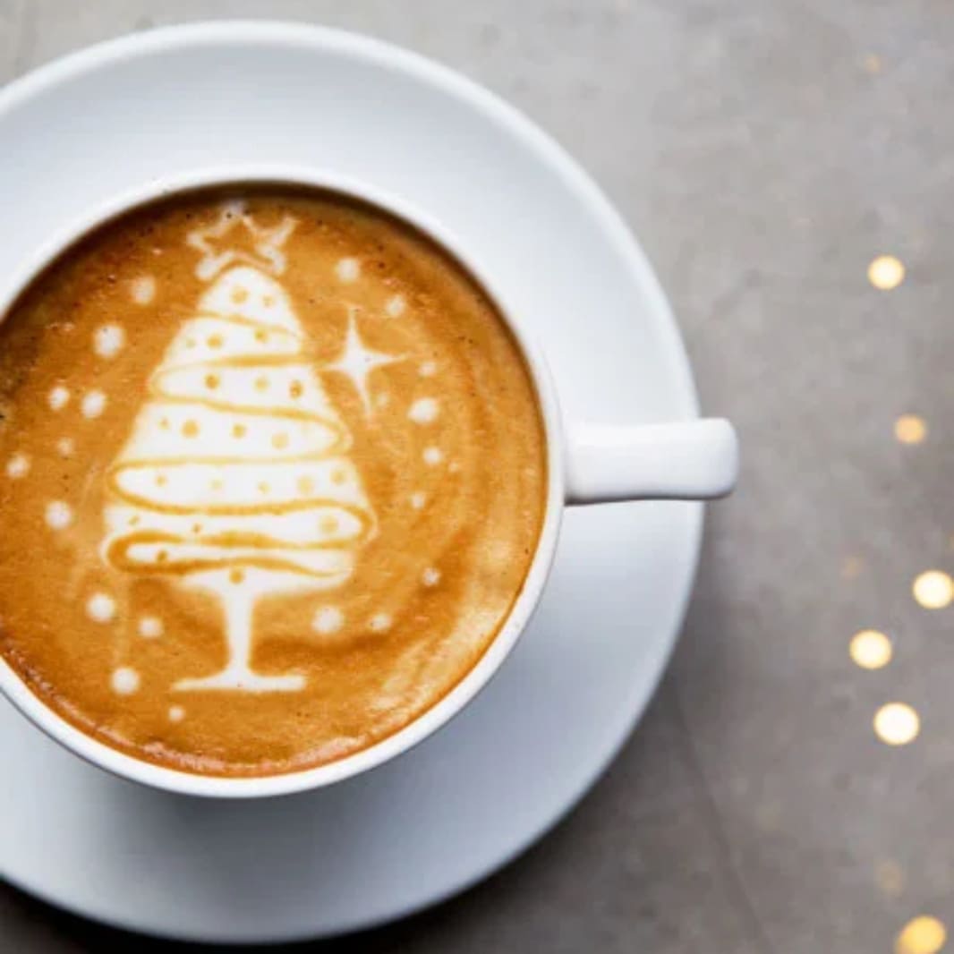 Latte con árbol navidad dibujado en espuma