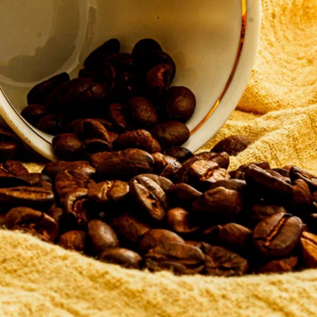 Taza regando granos de café