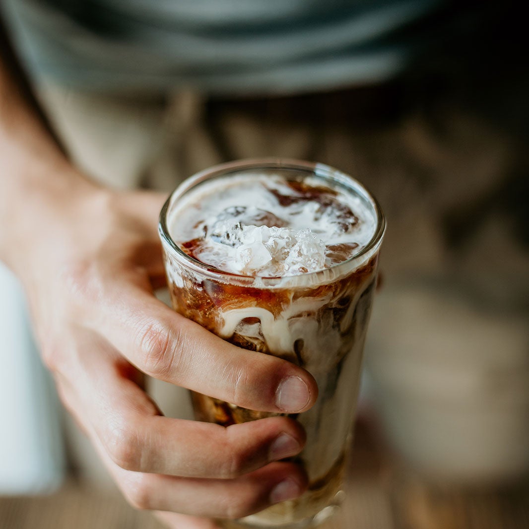 Una persona con un coctel de café sin alcohol en la mano