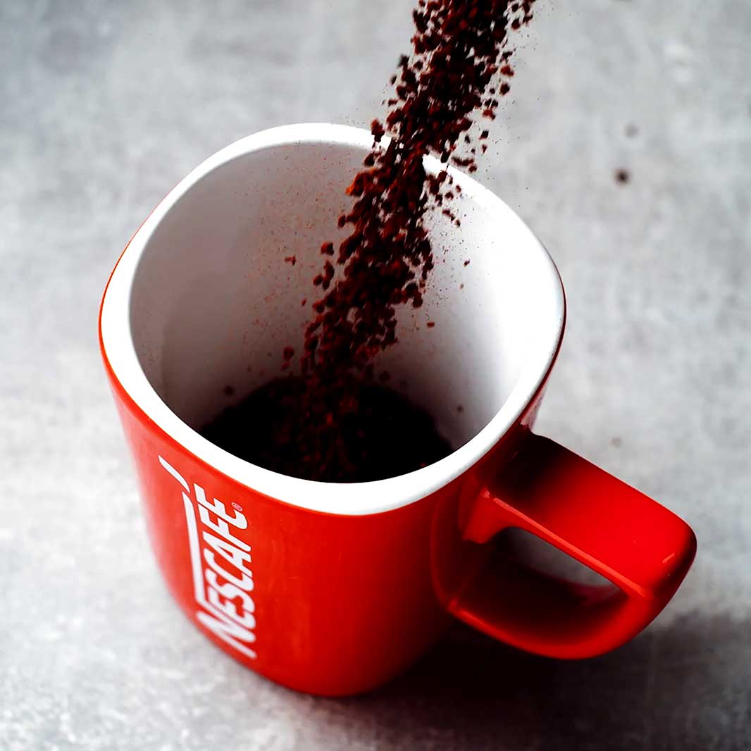 Una persona haciendo café con sal en un pocillo de NESCAFÉ® 