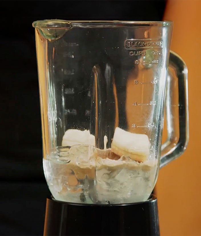 Licúa el hielo, el agua, el café y el banano hasta lograr una textura cremosa y sin hielos grandes.