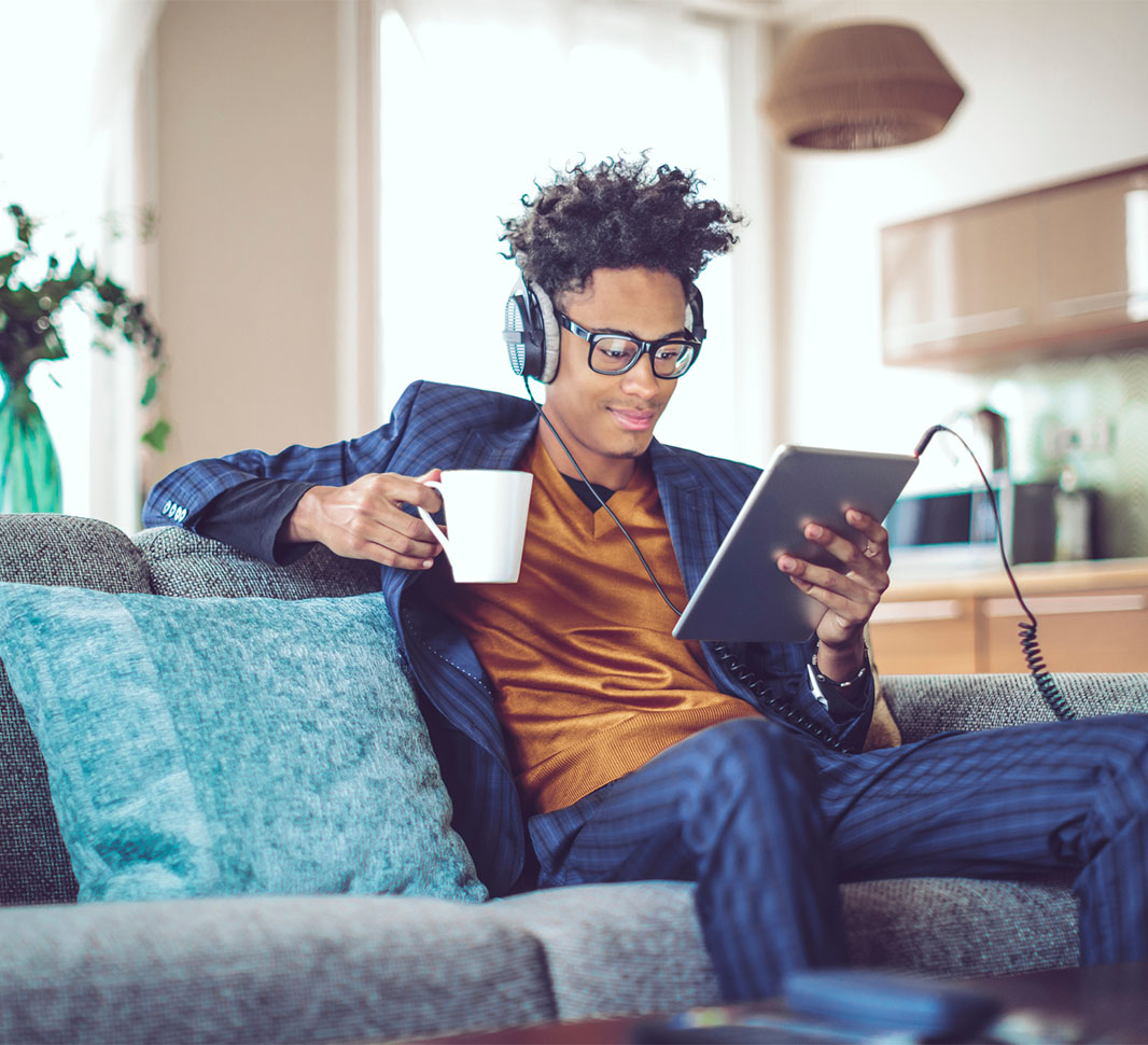 Hombre enfocado en su tablet y disfrutando de una taza de café