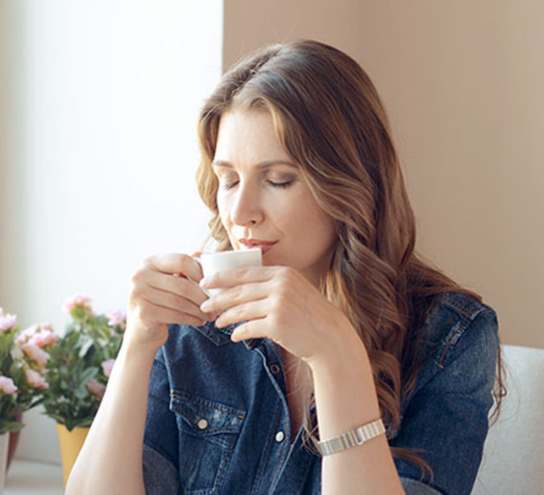 Mujer bebiendo una taza de café en su casa
