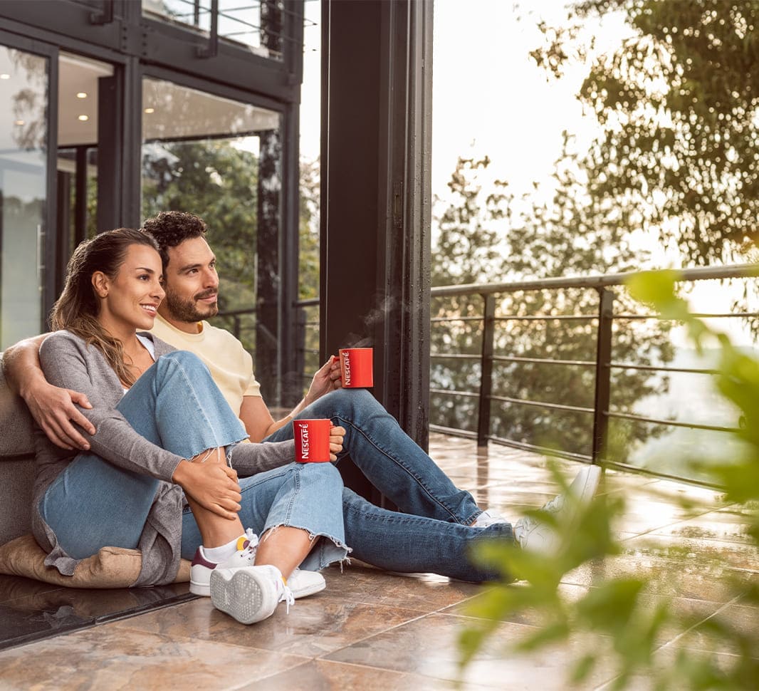 Dos personas tomando café NESCAFÉ® en su casa