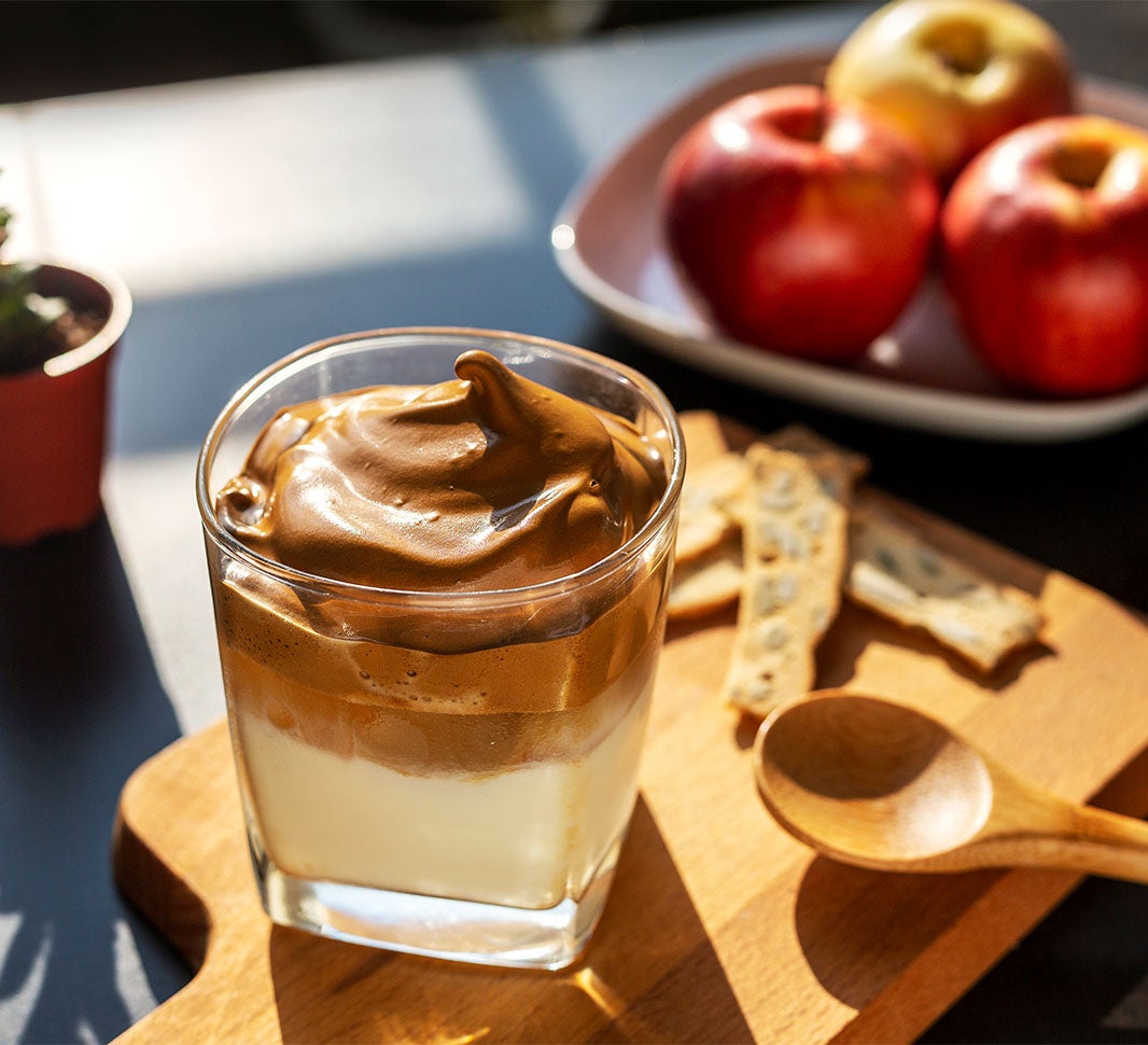Café sin azúcar con acompañamientos como manzanas y galletas