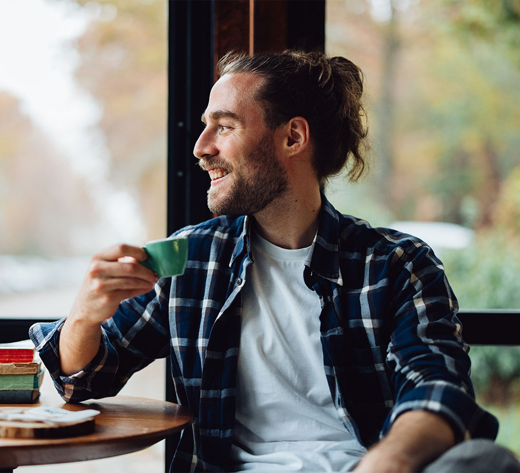 Hombre mirando la ventana y toma café después del almuerzo