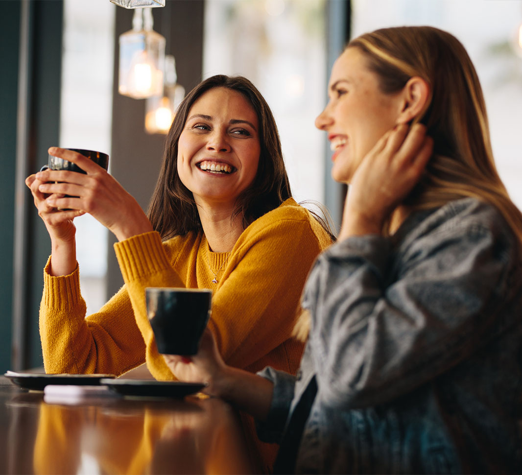 Dos mujeres en el trabajo aprovechan para tomar café