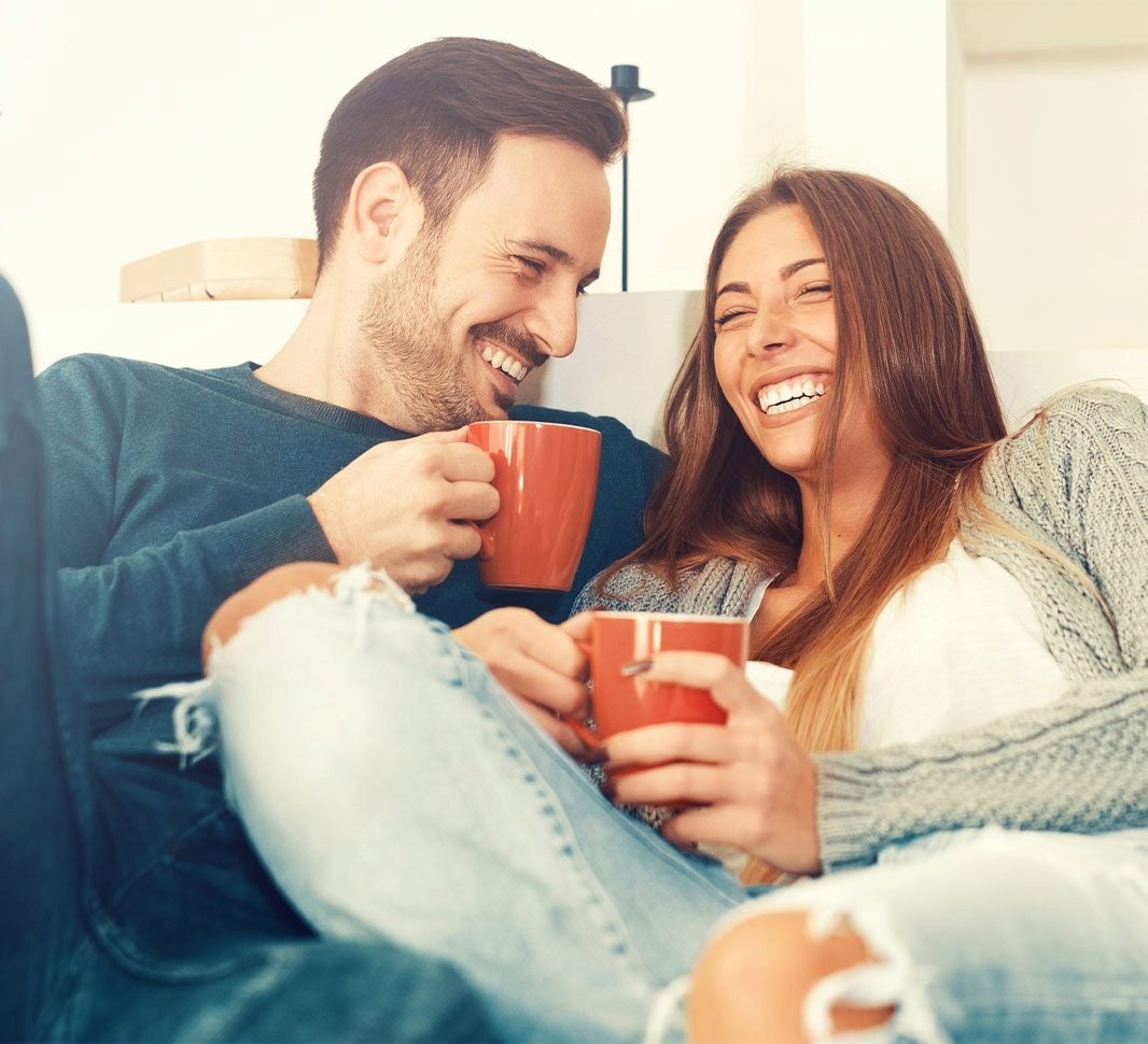 Dos personas con tazas de café en la mano  