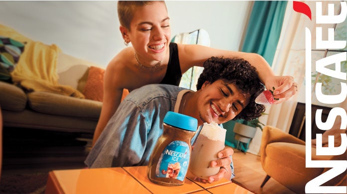 Bebida fría de café NESCAFÉ® ICE en vaso de vidrio, con pitillo rojo y lista para ser degustada.