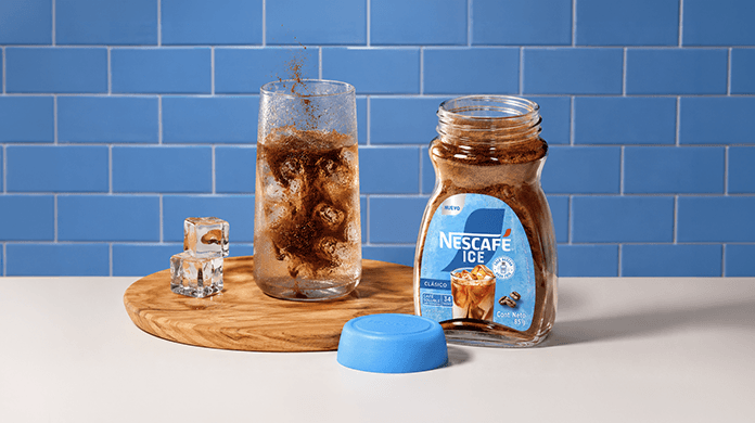 Bebida fría de café NESCAFÉ® ICE en vaso de vidrio, con pitillo rojo y lista para ser degustada.