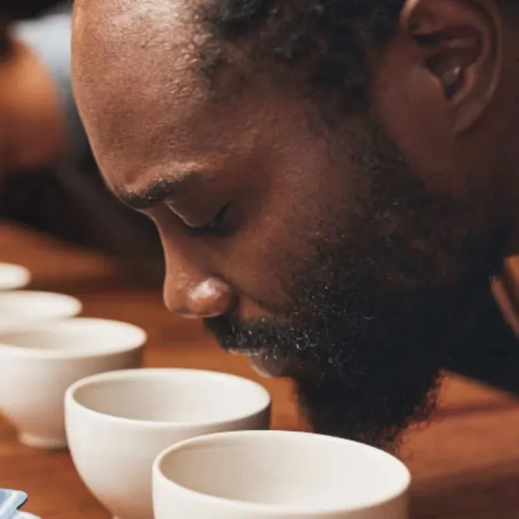 hombre oliendo taza blanca con cafe