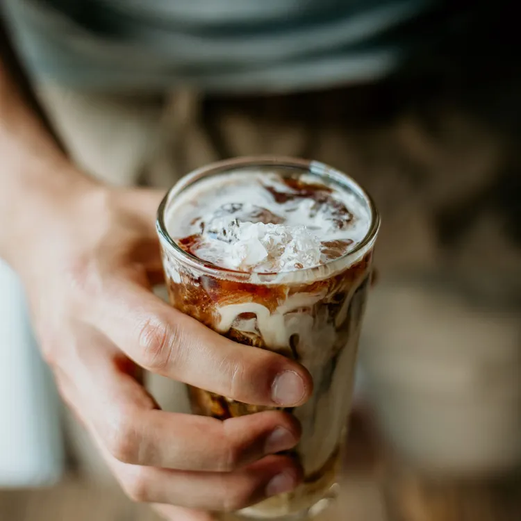 Una persona con un coctel de café sin alcohol en la mano