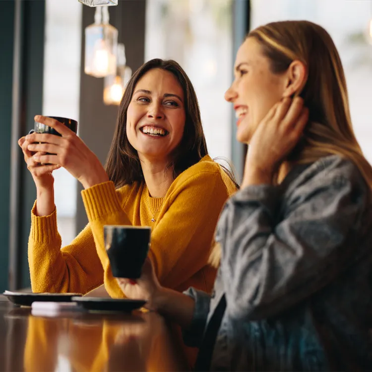 Dos mujeres en el trabajo aprovechan para tomar café