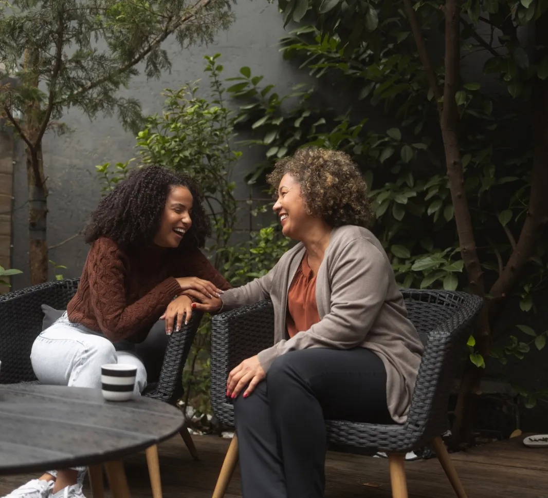 Mujeres sonrientes junto a una taza de flat white con NESCAFE