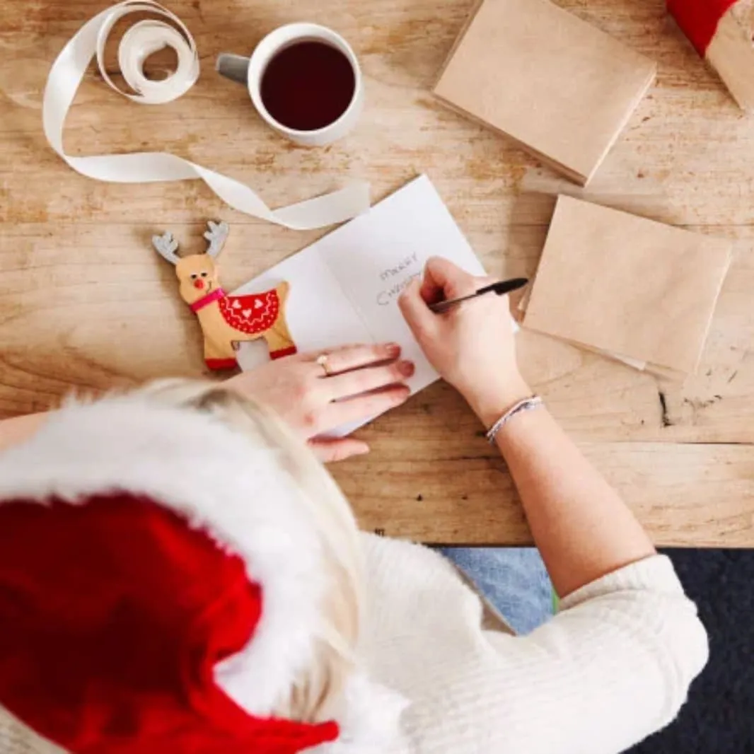 manos sosteniendo cafe rodeado de regalos