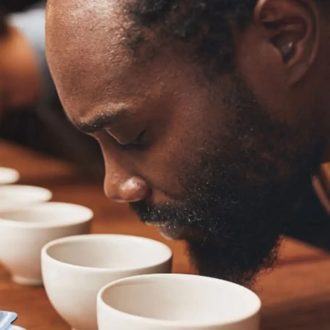 hombre oliendo taza blanca con cafe