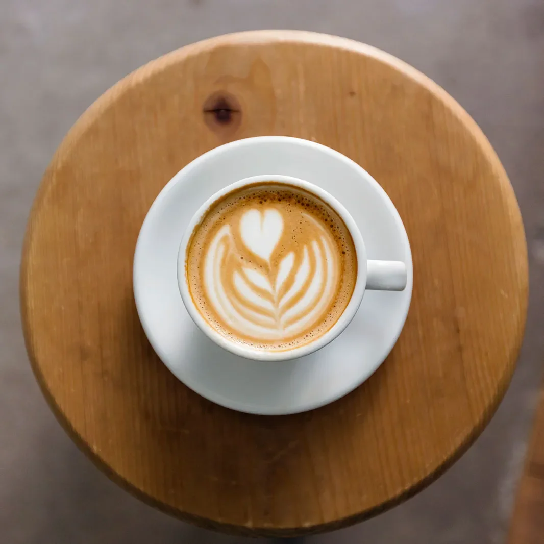 Un café au lait para estudiar con un plato de madera