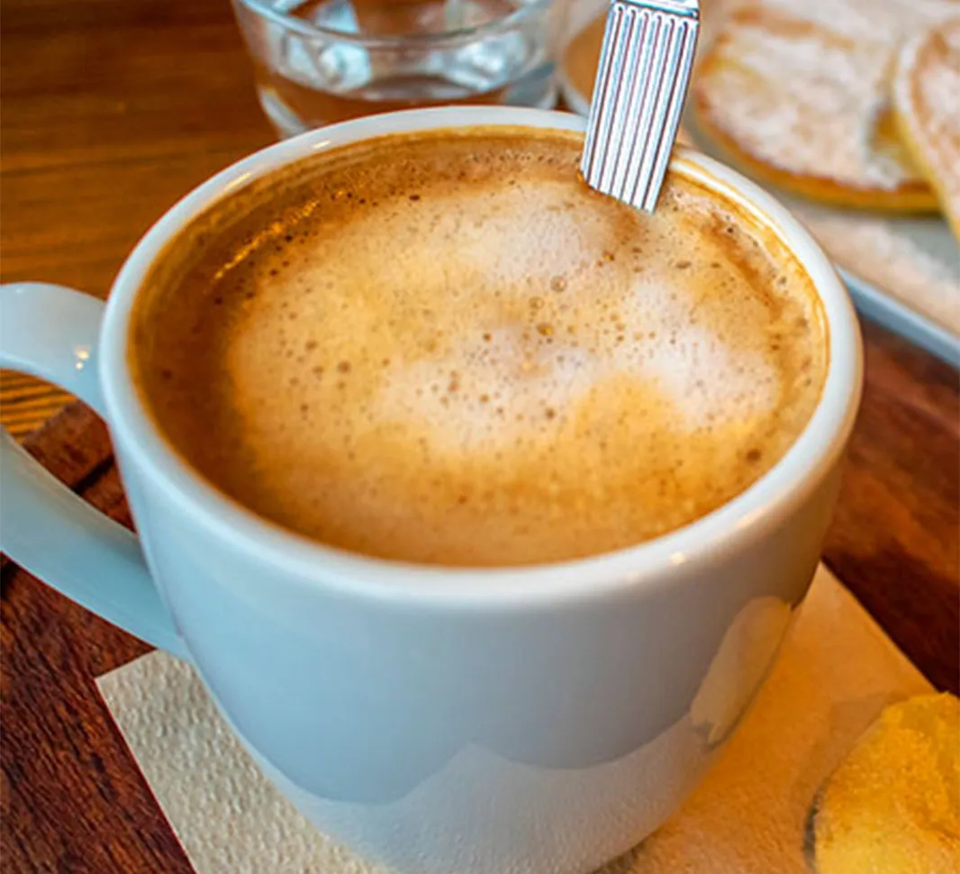 Taza de café cortado acompañado de tortillas con dulce de leche 