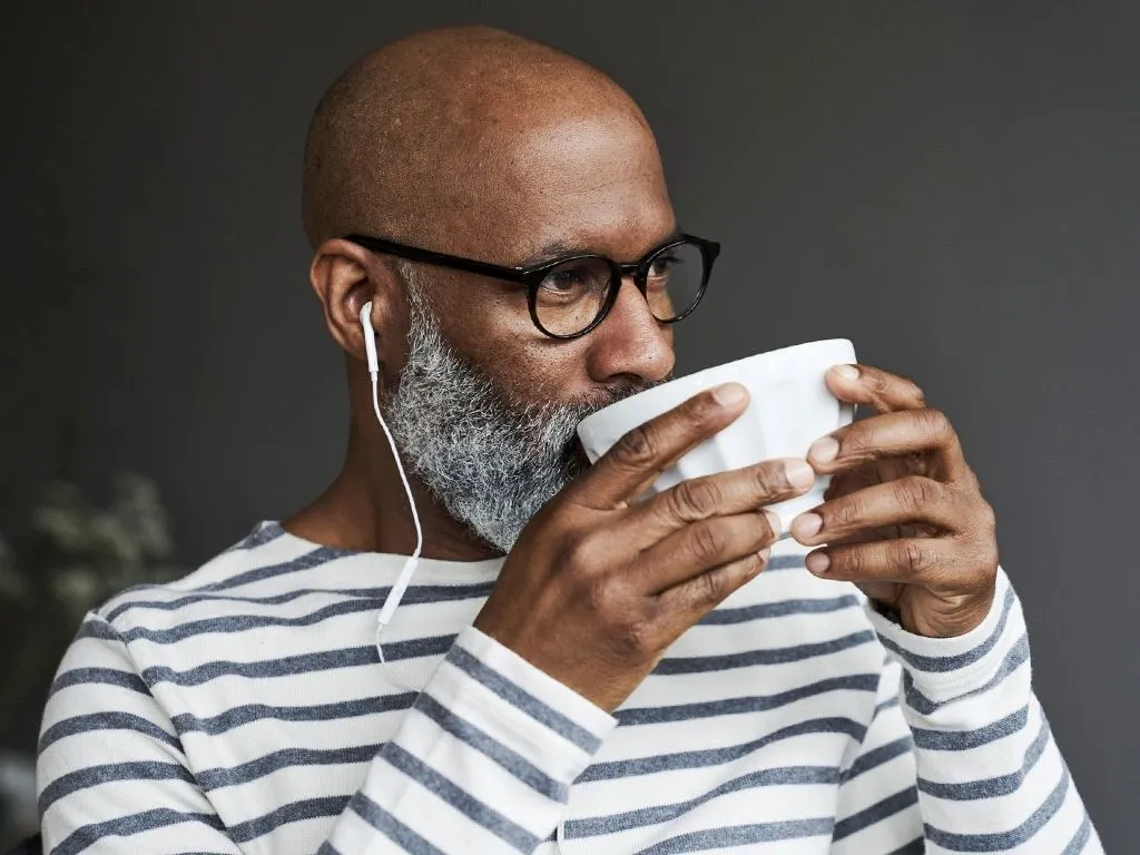 Hombre tomando café mientras escucha música