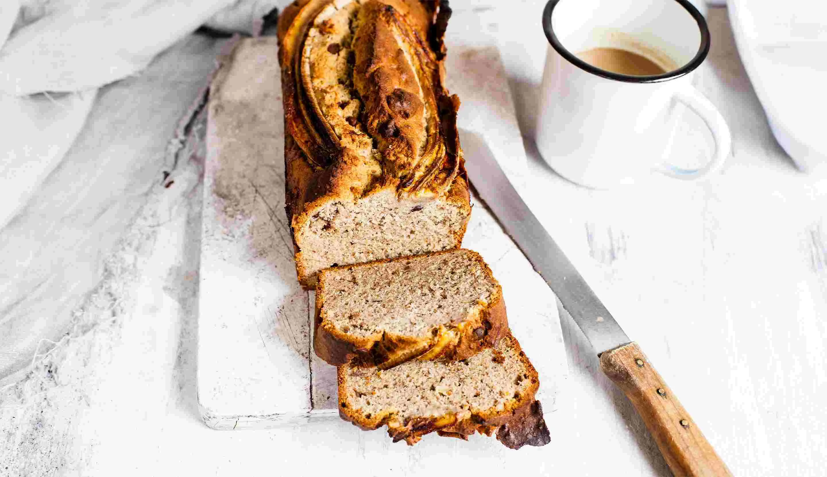 Café y pan cortado en una mesa  