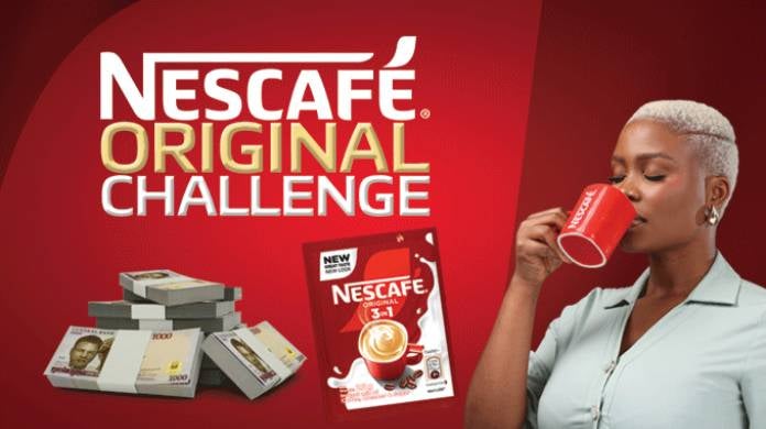 An excited man in a black shirt, holding a red NESCAFÉ mug